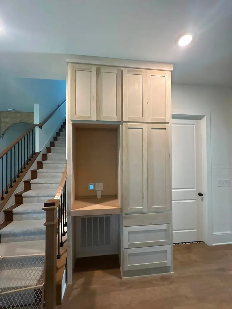 The finished built-in installed beside a staircase, doors closed, before finishing